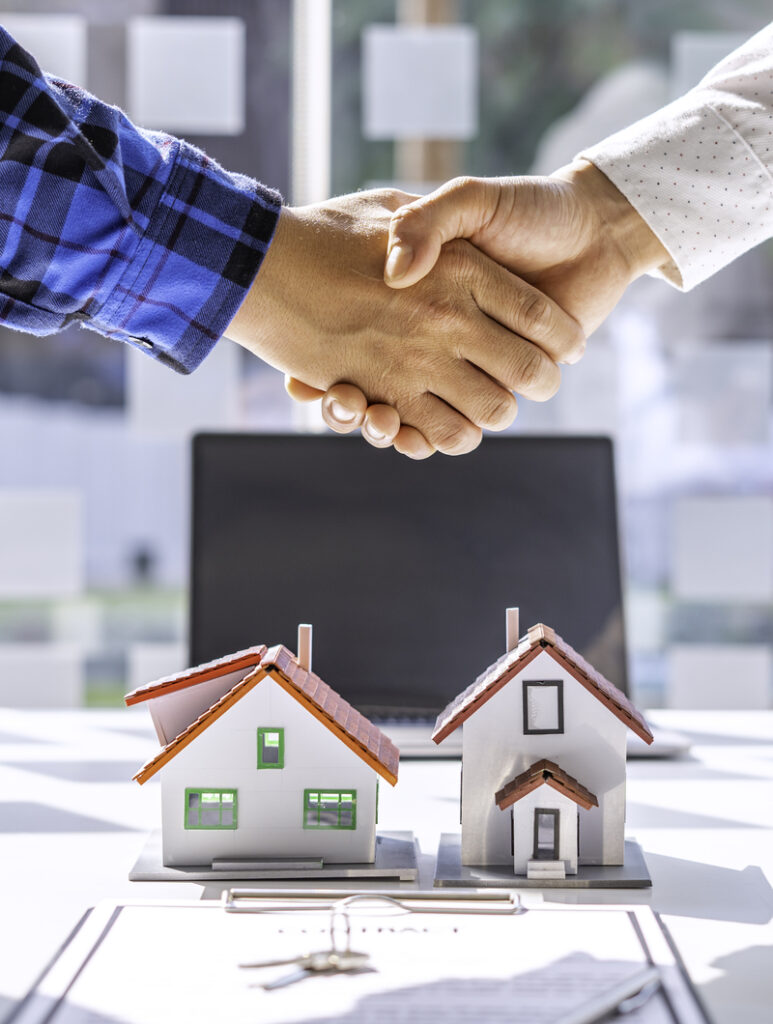 Real estate agents and clients shake hands and deliver the keys. After signing the contract to purchase ownership, the concept mortgage loan is approved.